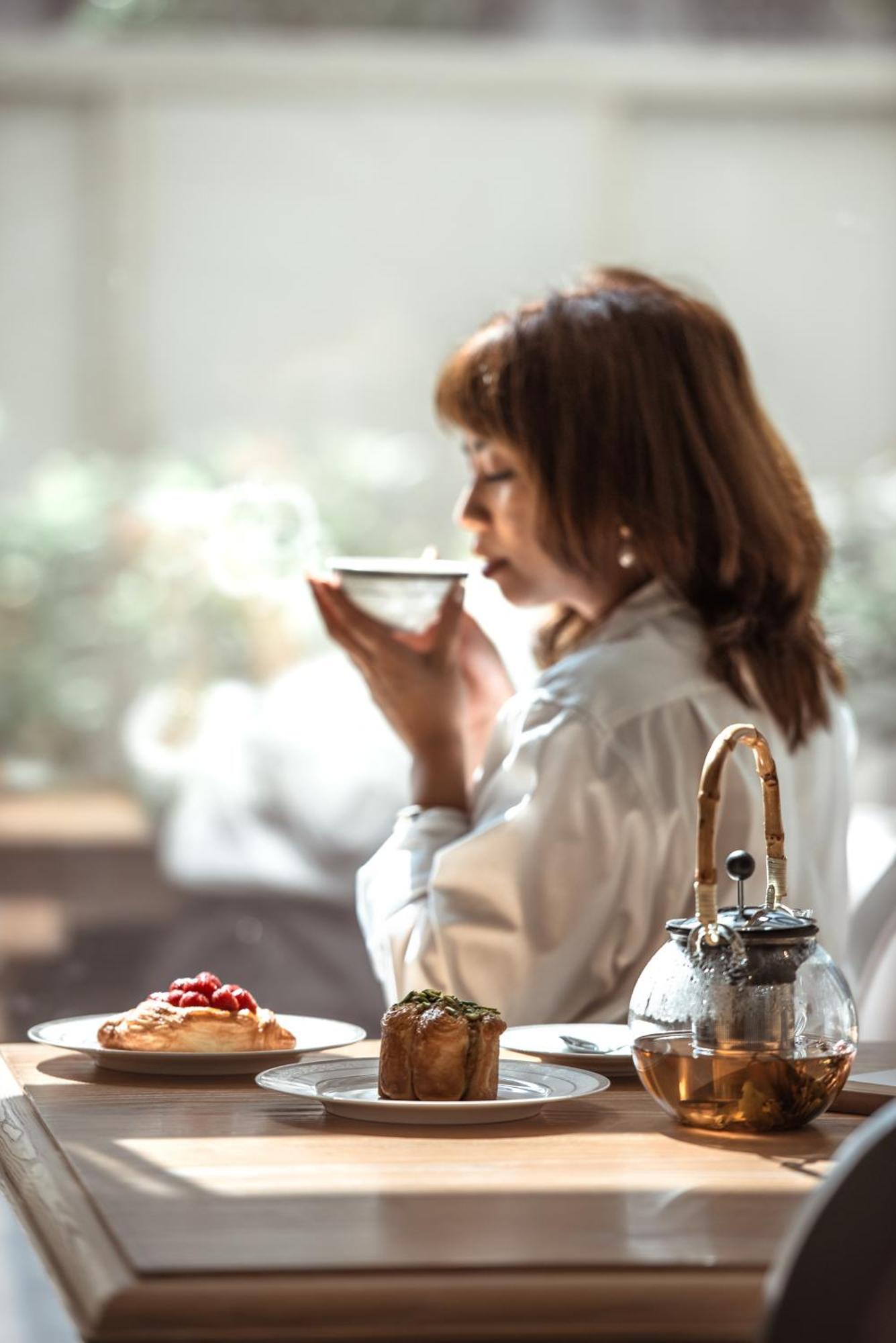 Dusit Doha Hotel מראה חיצוני תמונה A woman drinking tea