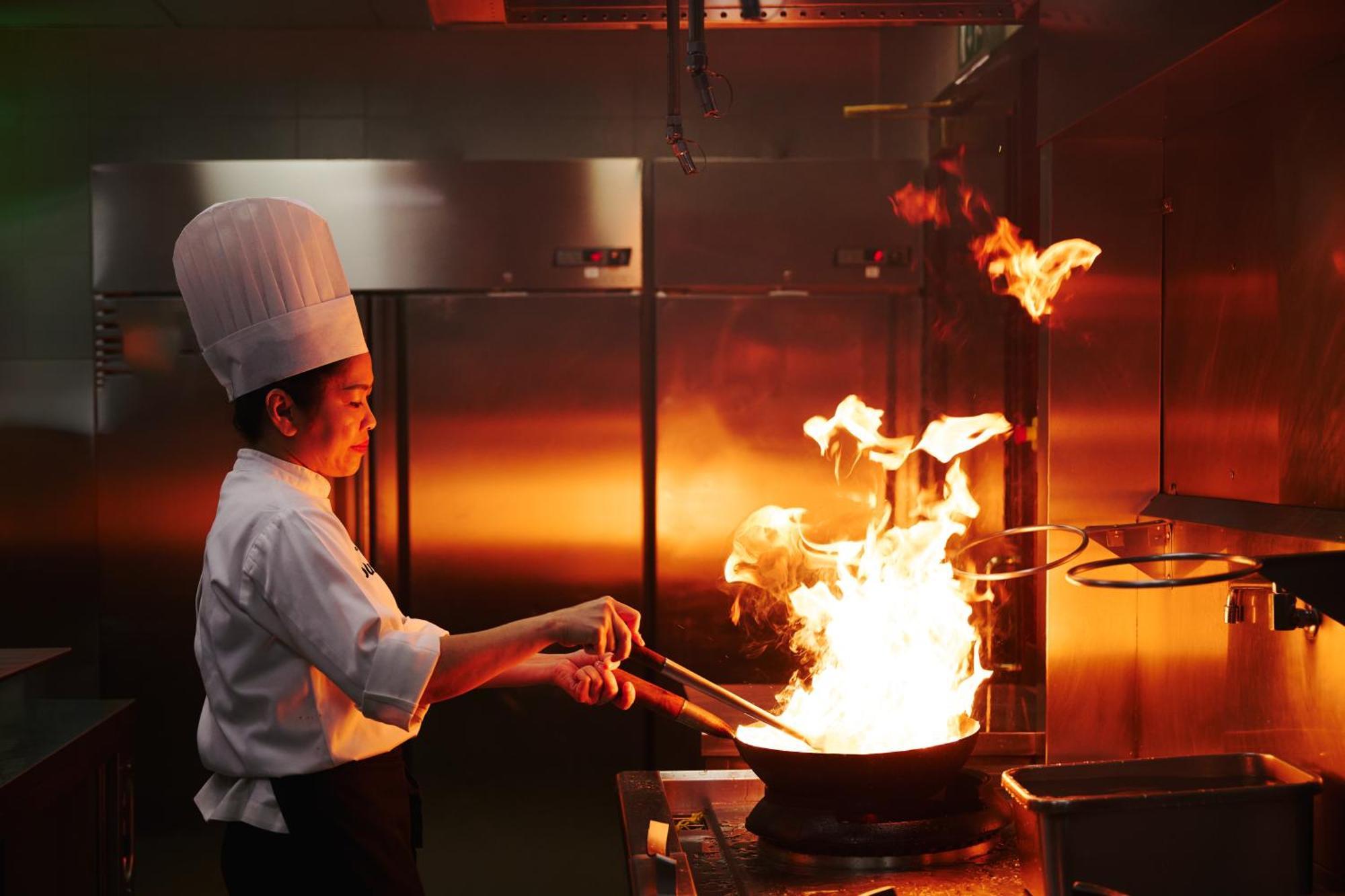 Dusit Doha Hotel מראה חיצוני תמונה A chef cooking with a wok